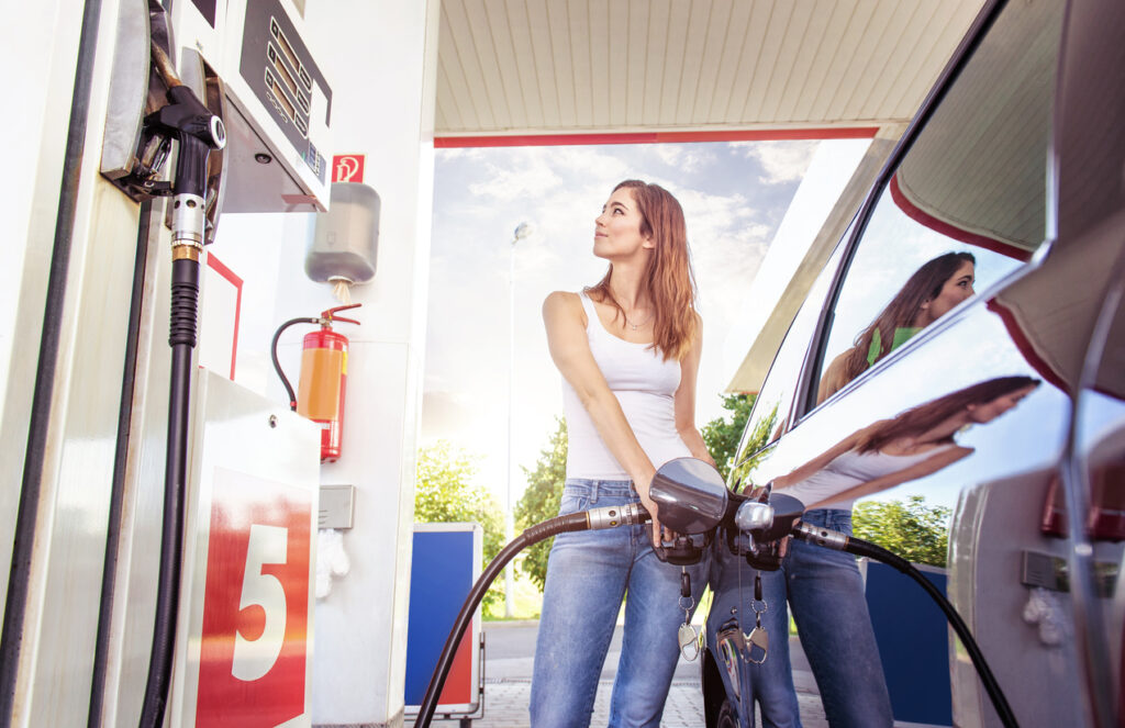 Jovem mulher abastecendo o carro num posto de gasolina para ganhar pontos no BR Premmia