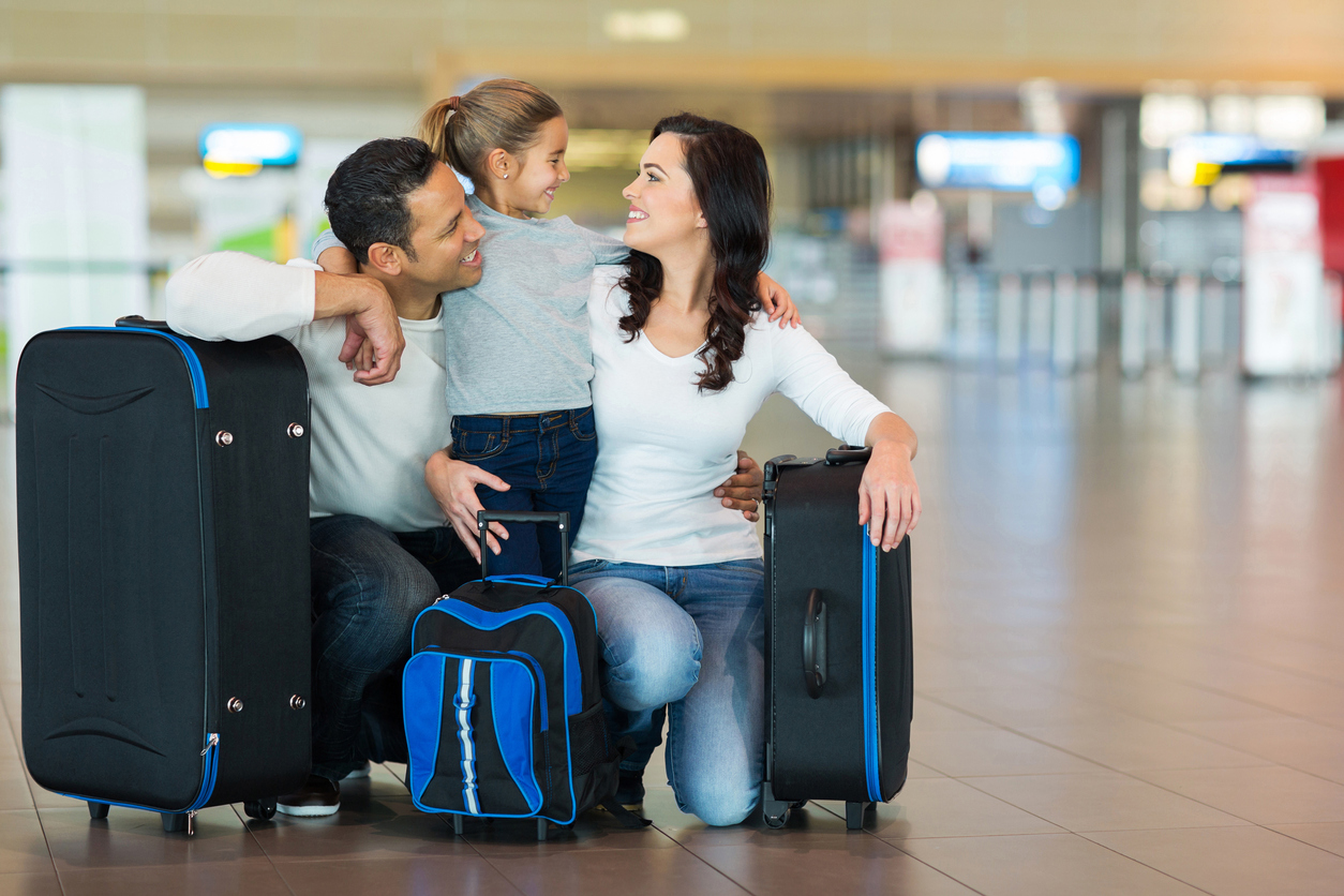Família feliz abraçando no aeroporto.
